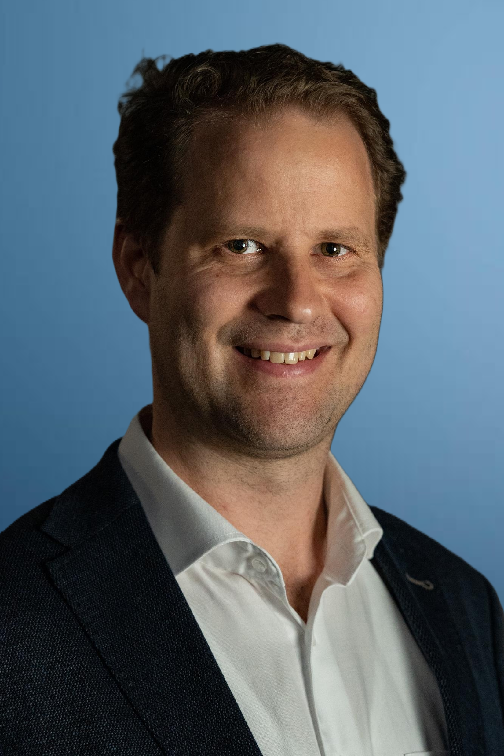Matthias Anderegg, Principal und Verhandlungsexperte bei Egger Philips, l&auml;chelt freundlich und offen in die Kamera. Er tr&auml;gt ein hellblaues Hemd und eine dunkelbraune Weste.